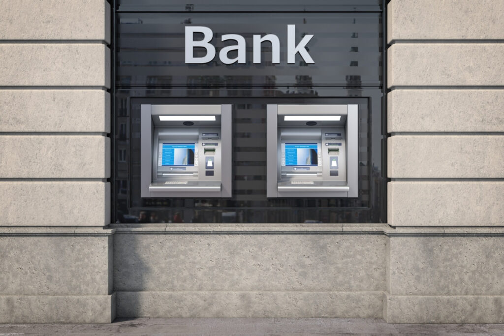 Bankomat na tle budynku banku ilustracyjnie przedstawia spory z bankami.