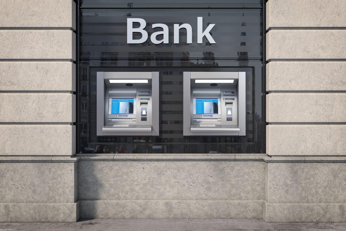 Bankomat na tle budynku banku ilustracyjnie przedstawia spory z bankami.