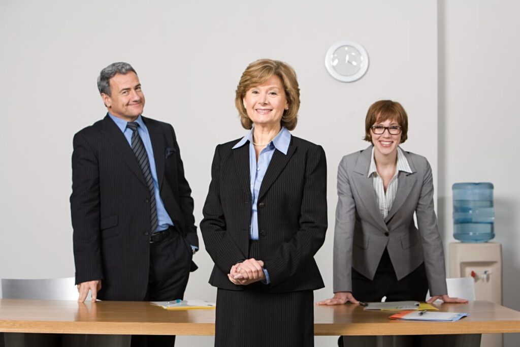 Troje osób w biurze, w tym adwokat w garniturze.