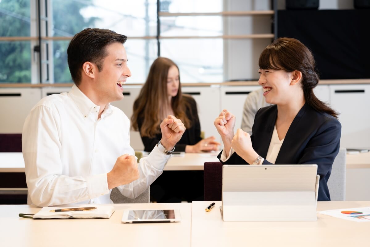 Dwie osoby z entuzjazmem dyskutują o temacie legalizacji pracy cudzoziemców w biurze.